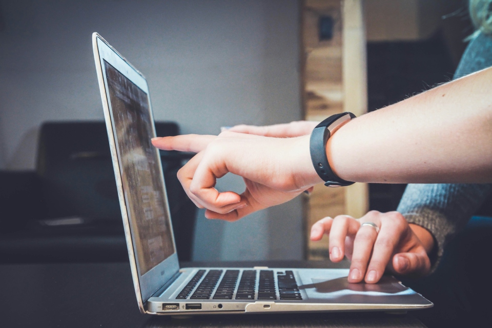 Hands interacting with laptop screen